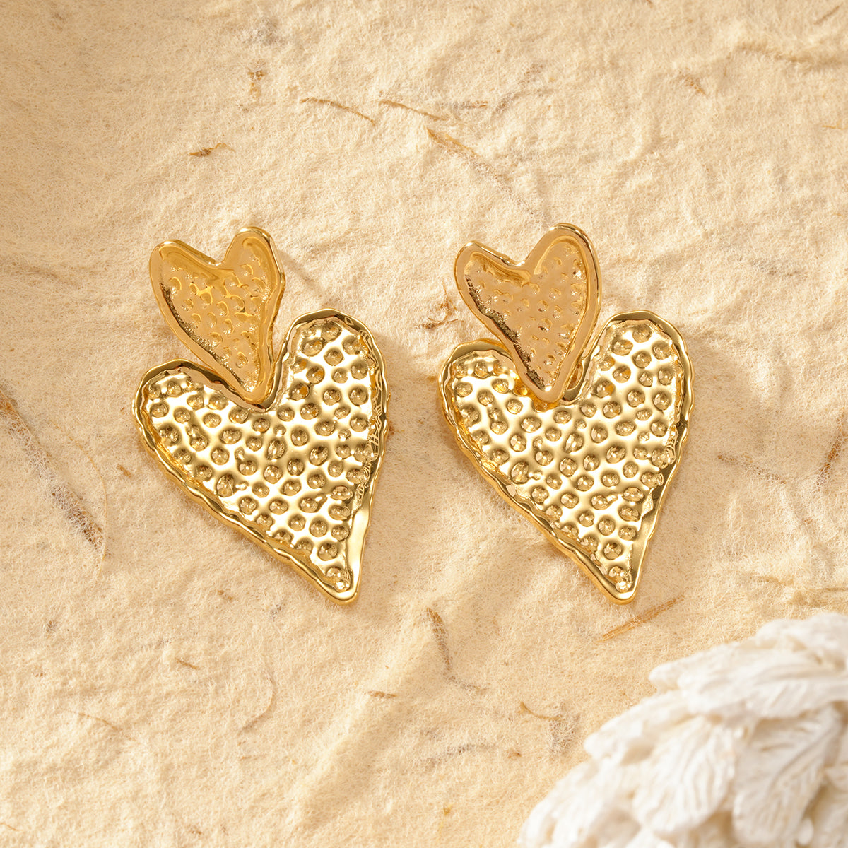 Boucles d'oreilles dorées double coeurs pendants texturés