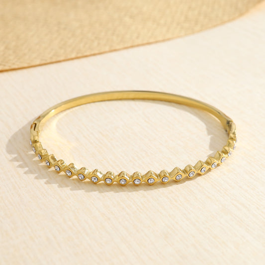 Bracelet jonc doré orné de forme rondes et losanges strassés