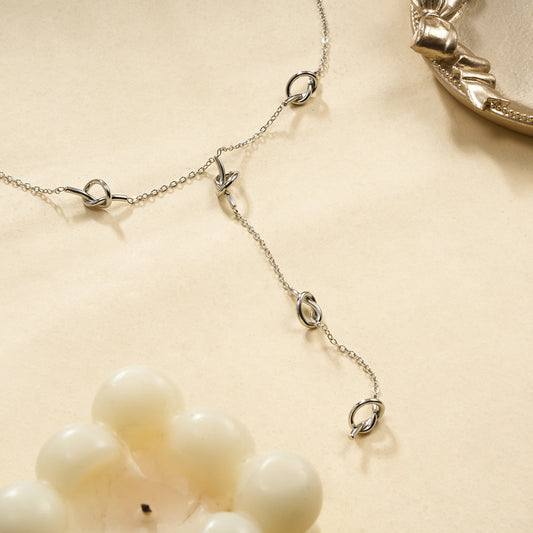 Collier chaîne fine en Y orné de nœuds d'amour