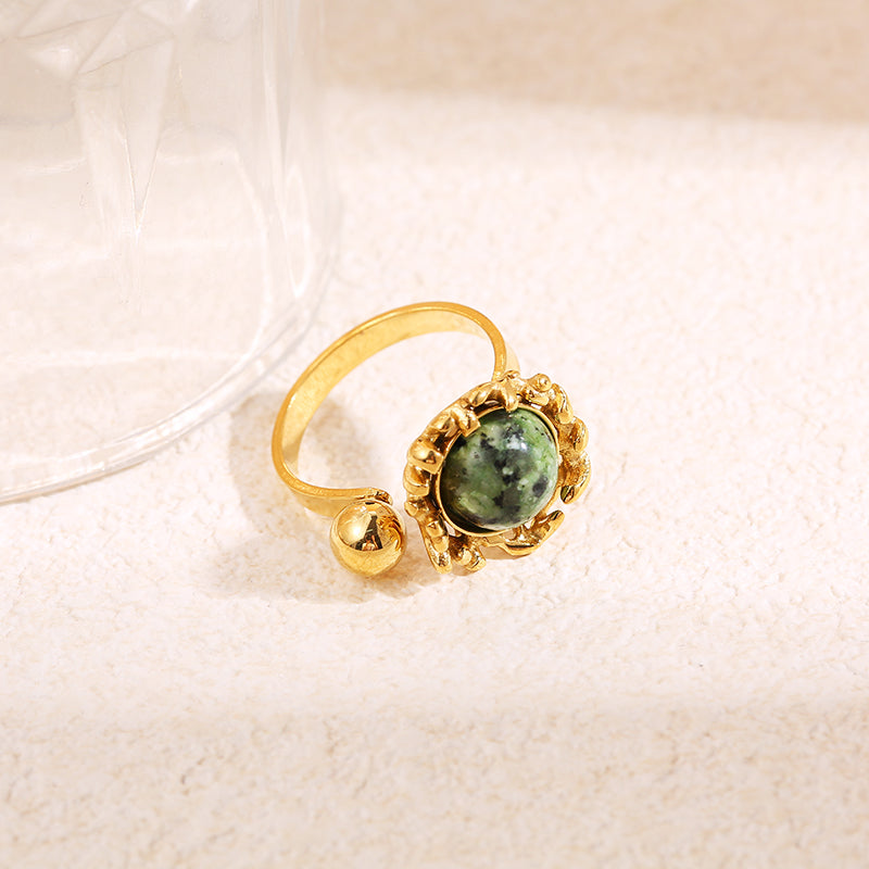 Bague dorée ouverture devant boule avec pierre