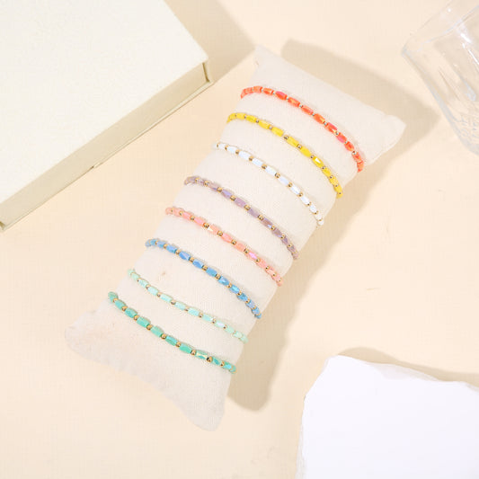 Lot de 8 bracelets fins séparateurs dorés perles couleurs diverses sur coussin